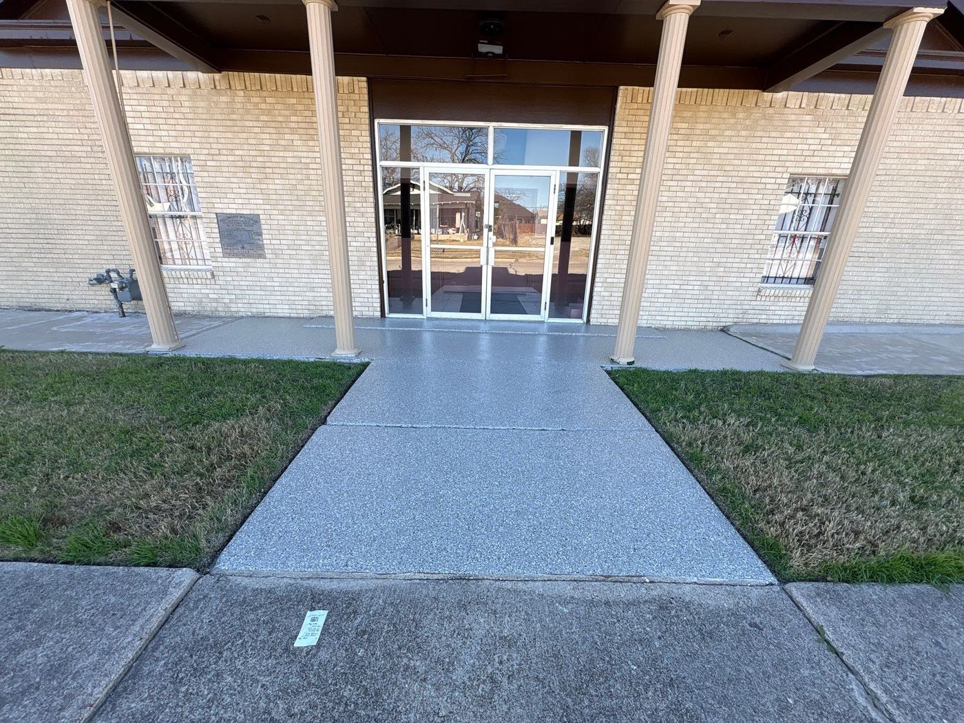 Commercial entrance walkway coated with Penntek polyurea grey color flake — Dallas Fort Worth